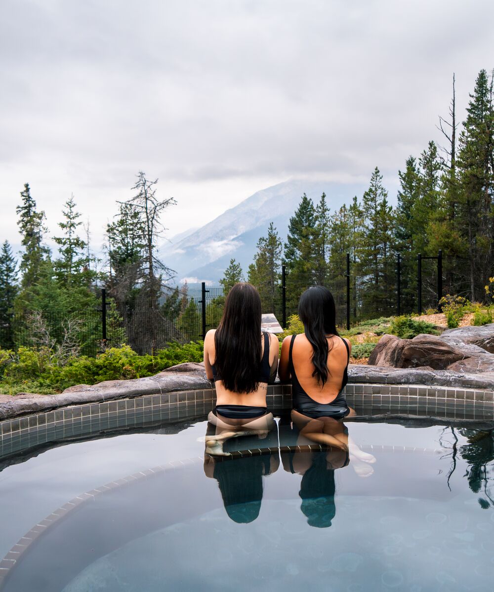 Two people in a hot tub at Hidden Ridge Resort in Banff.